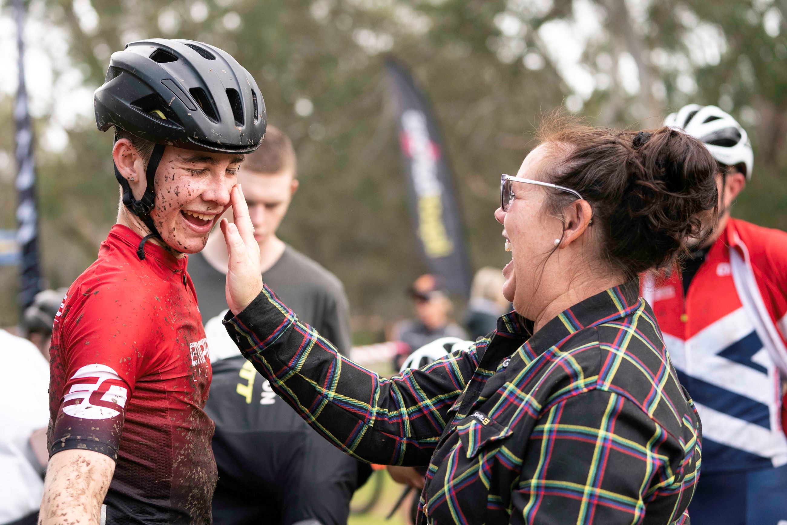 West Australian junior cyclist Cooper Dunlop shares a laugh with his mother Michelle Dunlop as she wipes mud off her son's face after a cyclo-cross race